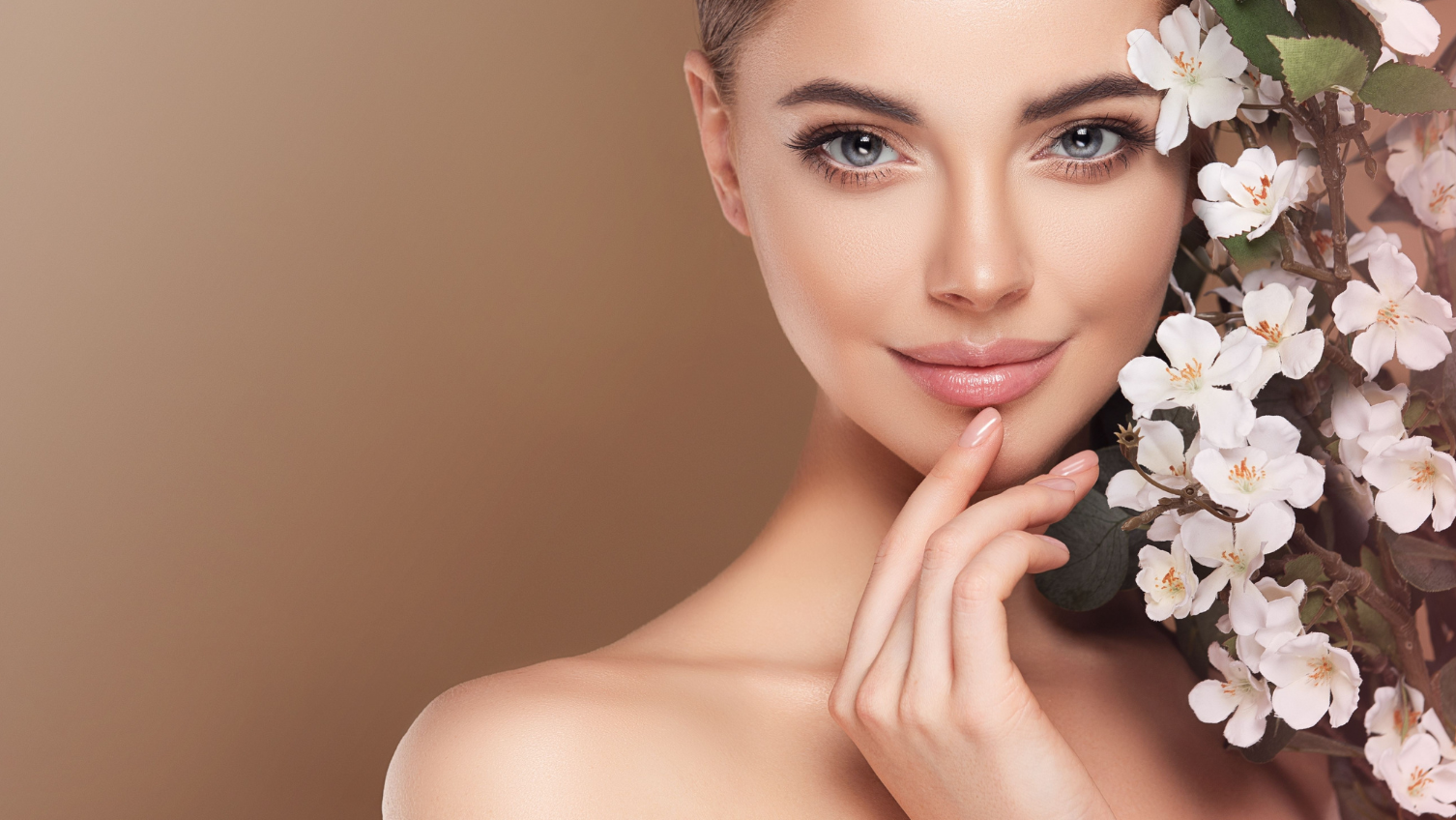 Woman with a bouquet of flowers against a beige background